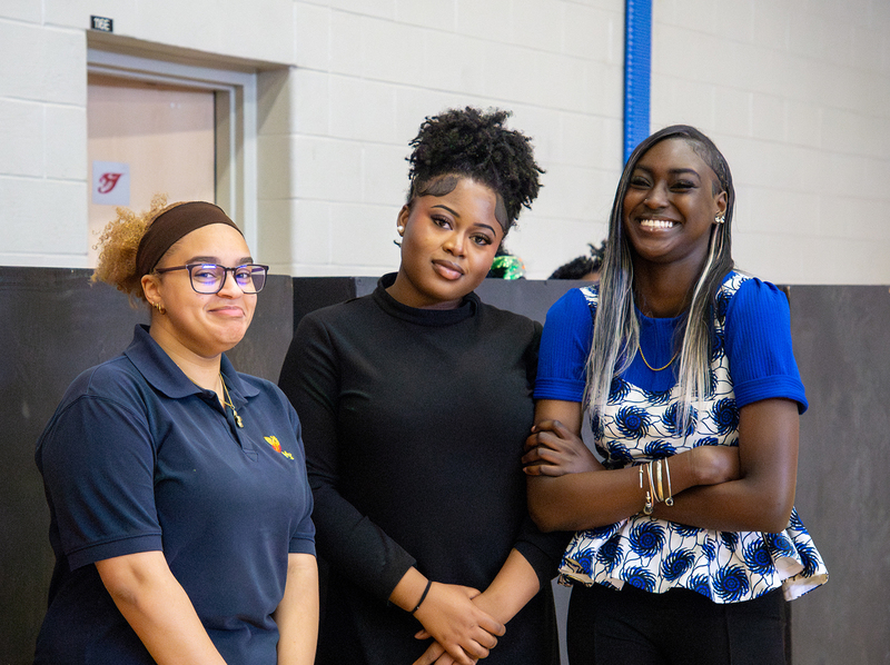 Photo of three students and attendees at the event