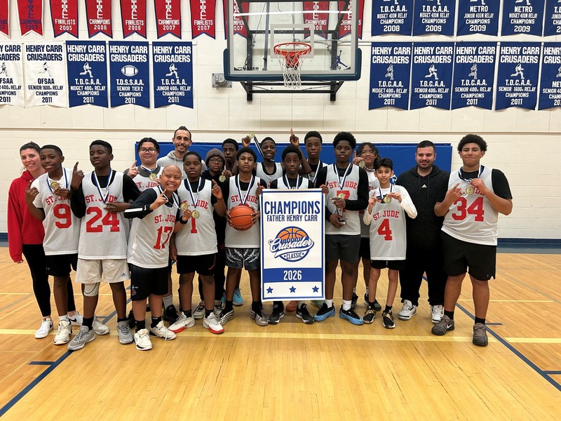 Basketball team champions posing with 2026 Champions banner