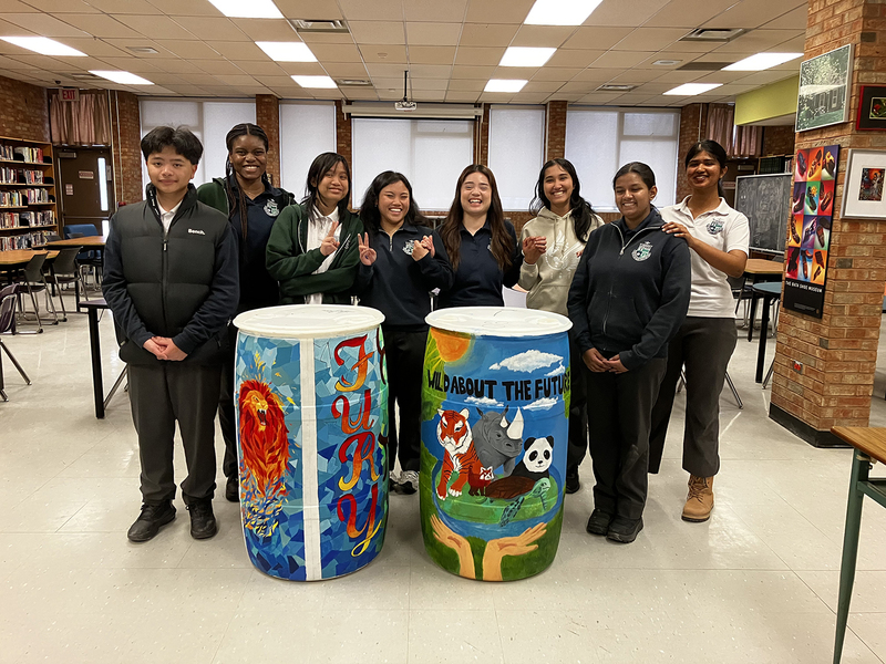 Photo of students from the Libermann Green Team and the Creatives Club with the two chosen barrel designs