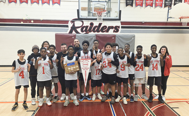 Group photo of the St. Jude boys basketball team with their championship awards