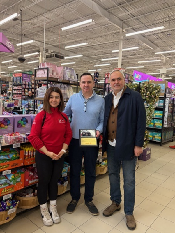 Photo of Michelle Bottos presenting David Hicks with a commemorative plaque on behalf of the St. Paschal Baylon community