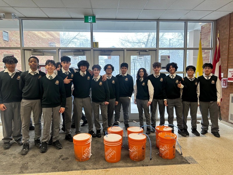 Group photo of Chaminade students with the syrup they collected