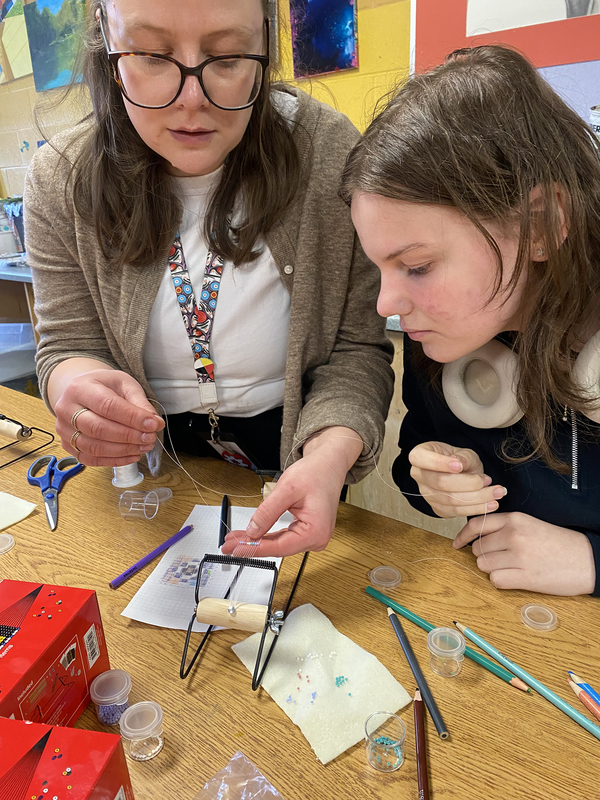 Photo of students working on their beading