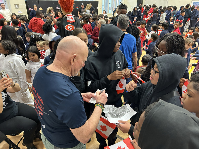 Photo of Fred Fox mingling with St. Andre students at the assembly