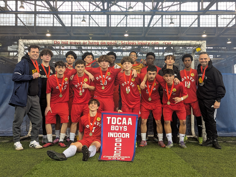 Group photo of Dante team in front of the net with their championship banner