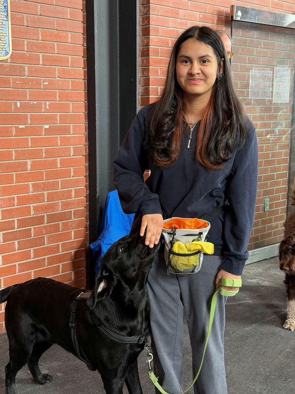 Photo of a Redmond student with the therapy dog they helped to train