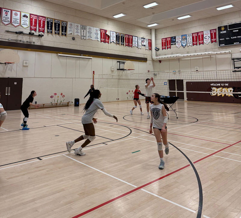 Photo of Mason coaching SJCS athletes on the court