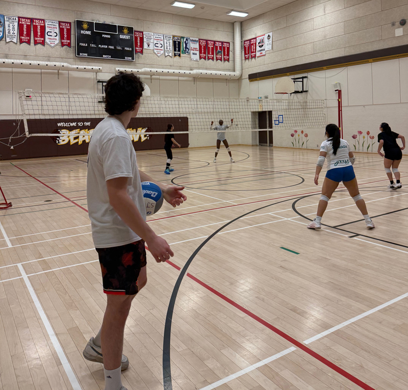 Photo of Mason coaching SJCS athletes on the court