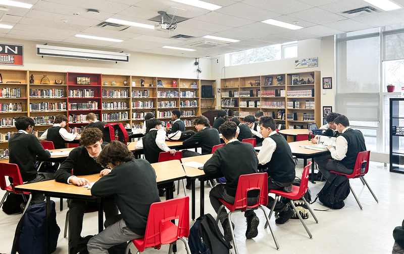 Photo of Chaminade students tutoring their students in the library
