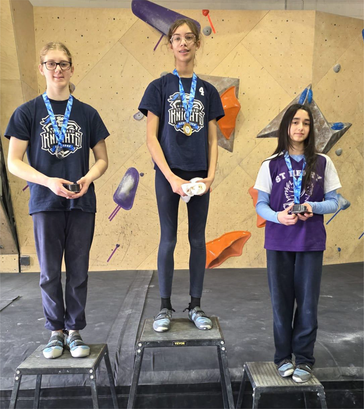 Photo of the three girls winners on the podium with their medals