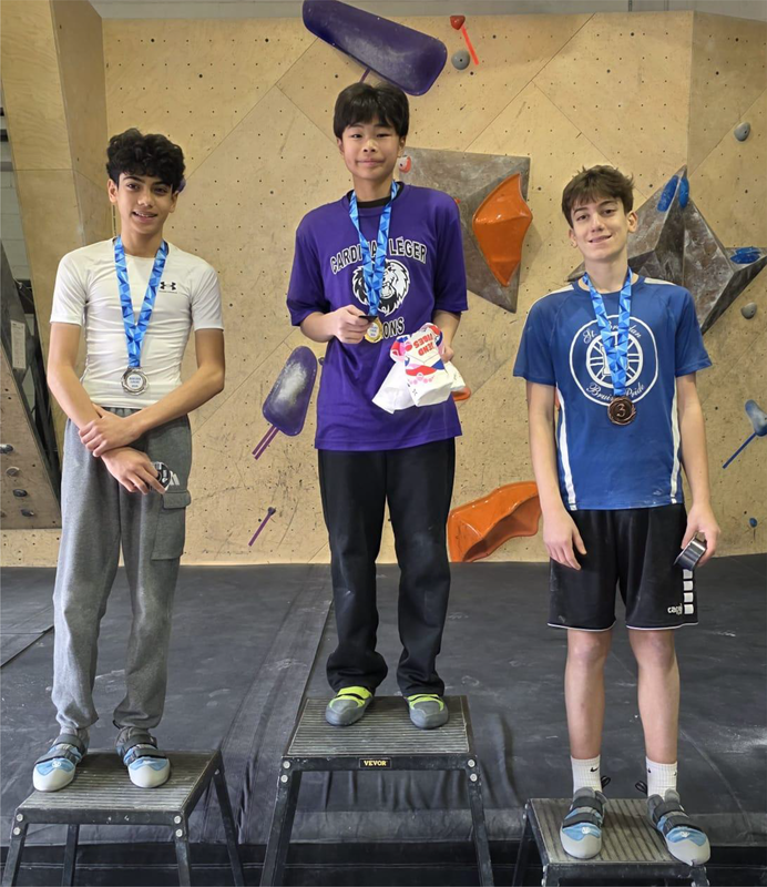 Photo of the three boys winners on the podium with their medals