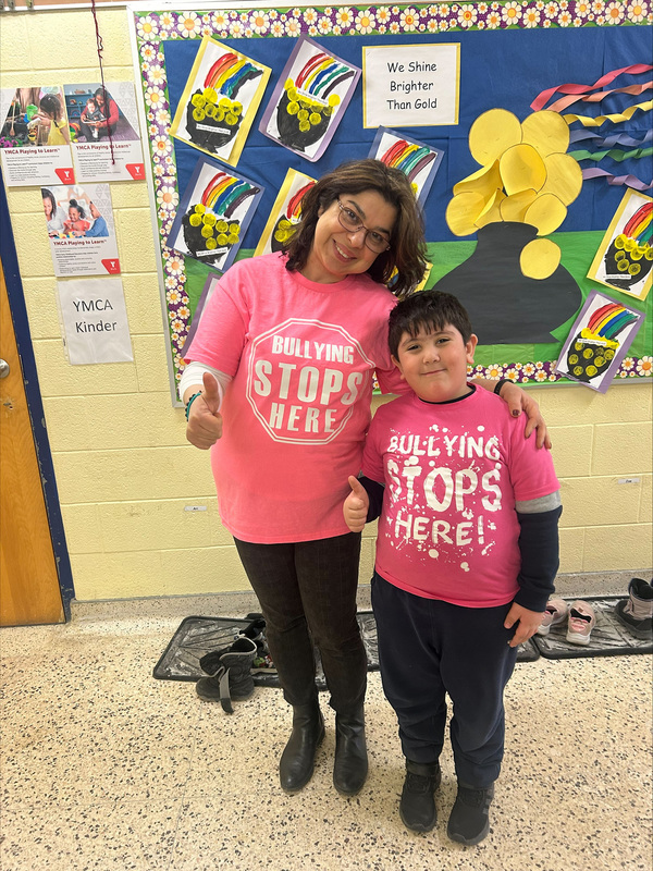 Photo of a teacher and a student wearing pink shirts against bullying for Pink Shirt Day
