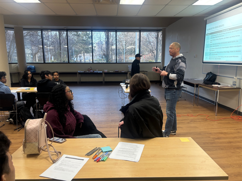 Photo of Glendale Reyes teaching Newman students the foundations of breakdancing