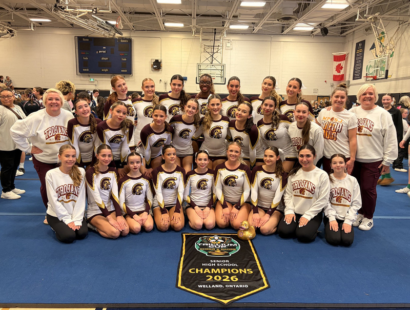 Group photo of the MPSJ Cheer Team with their championship banner