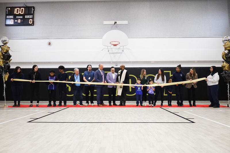 Photo of St. Roch staff and students along with TCDSB senior staff cutting the ribbon on the newly renovated gym