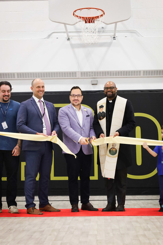 Photo of St. Roch staff and students along with TCDSB senior staff cutting the ribbon on the newly renovated gym