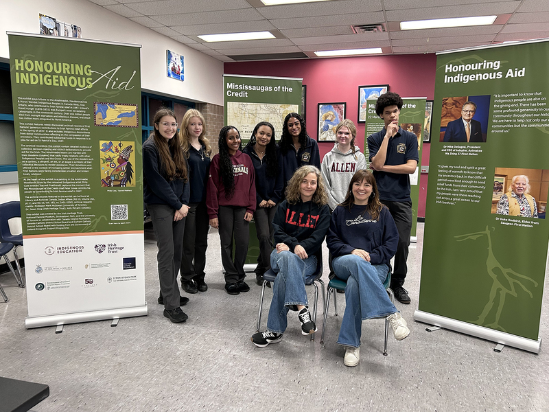 Group photo of Bishop Allen students and teachers with the exhibit