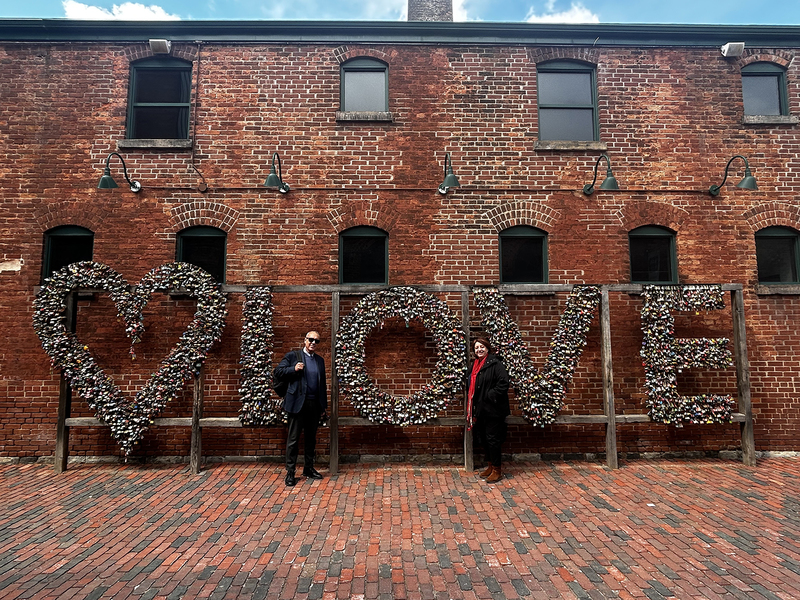 Photo of Italian exchange educators in front of a brickworks display that spells out LOVE with a heart symbol