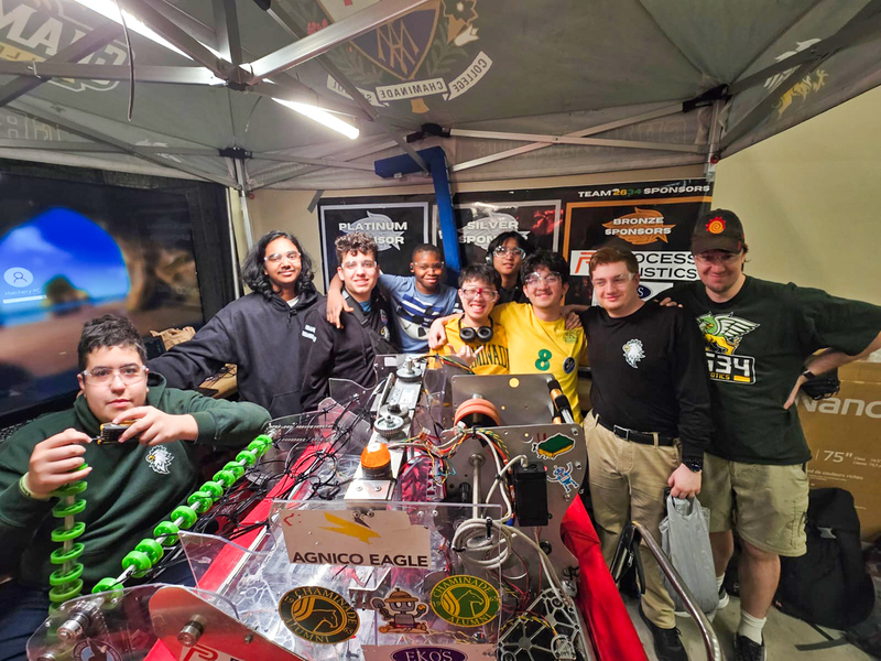 Group photo of the Chaminade Robotics team with the machine that they built