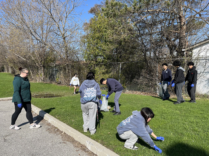 Photo of SJOA students cleaning up in the school grounds