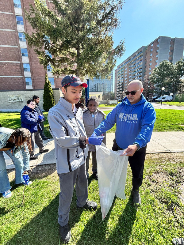 Photo of SJOA students cleaning up in the school grounds along with SJOA stuff