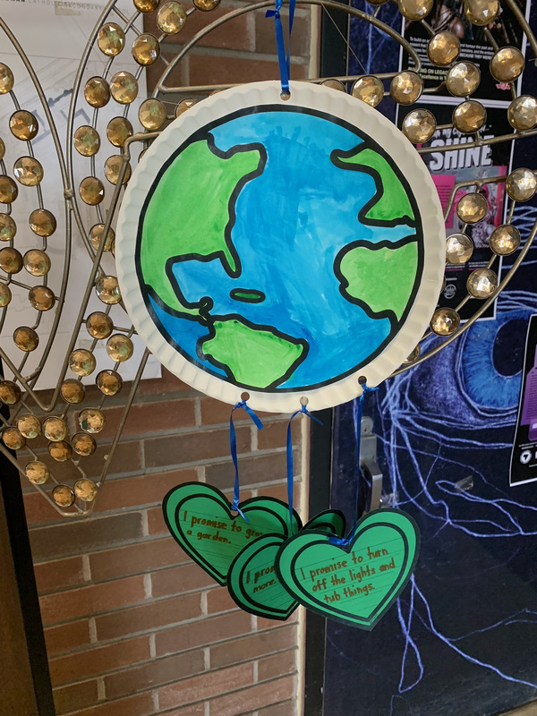 Photo of an Earth Day artwork display showing a cardboard cutout of the earth along with messages written on great cutout hearts