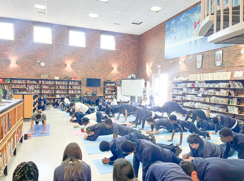 Photo of students doing physical activity in the library during the Wellness Day