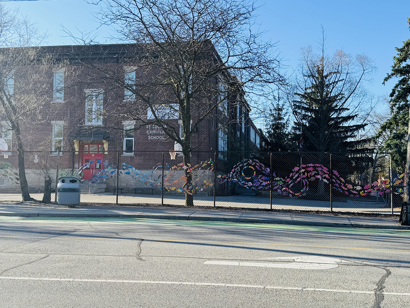 Photo of the outside of the school building with the fishes running across the fence