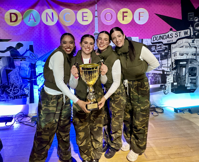 Photo of four members of the Loretto Dance Team holding their championship trophy
