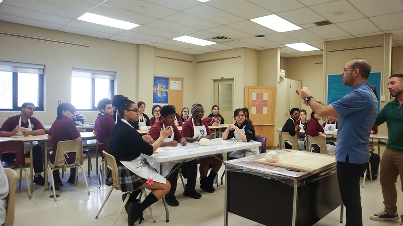St. OScar Romero students being coached by chef