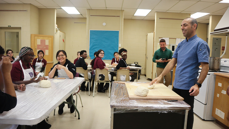 St. OScar Romero students being coached by chef