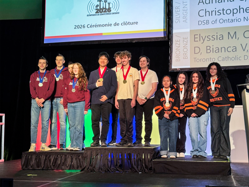 Photo of the MPSJ Robotics team on the podium with their medals, along with the students from the runner -up teams
