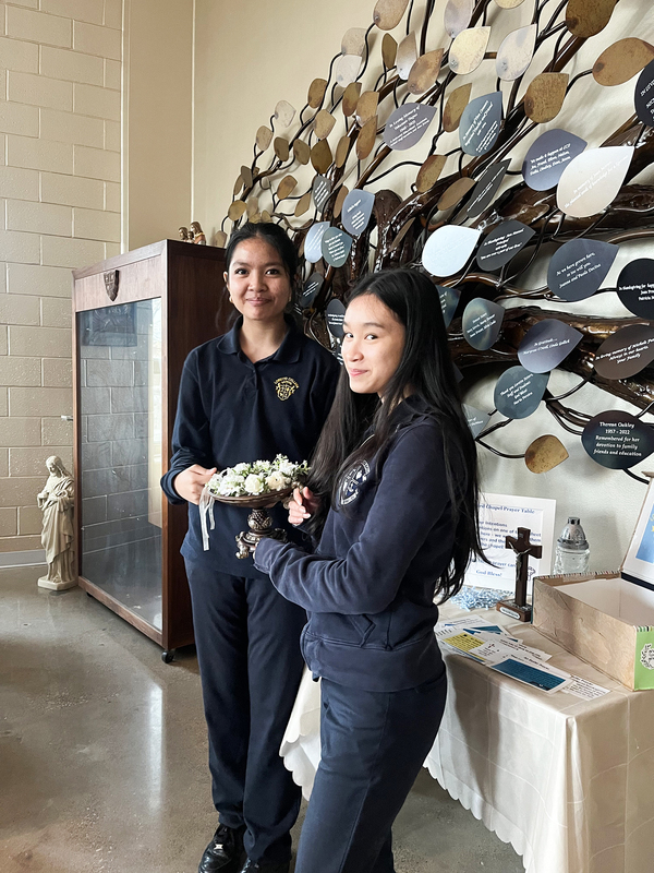 Photo of two students helping out with the Mass