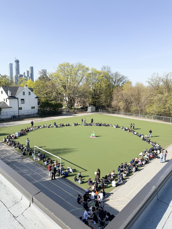 Photo of Our Lady of Perpetual Help students and staff making up a living rosary on the school grounds, photographed from above