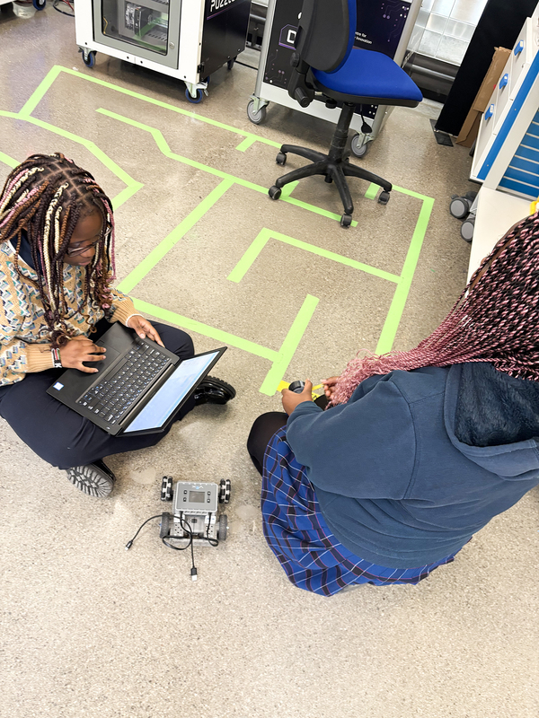 Photo of Madonna students working on coding their robots