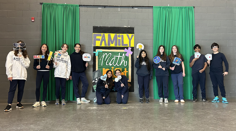 Photo of St. Ambrose students at Family Math Night with their props