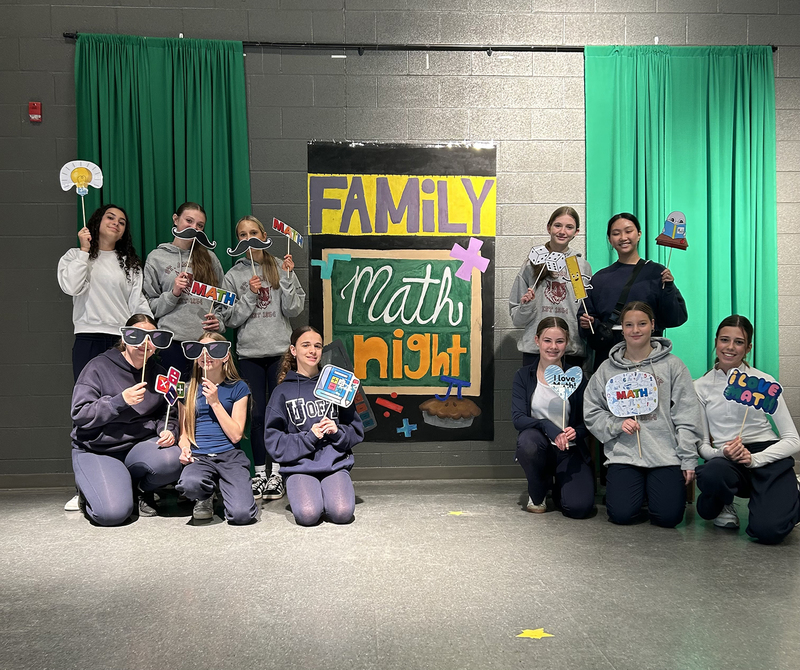 Photo of St. Ambrose students at Family Math Night with their props