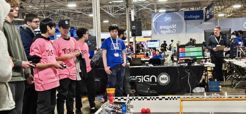 Photo of the OCS Robotics team students operating their robot during the competition