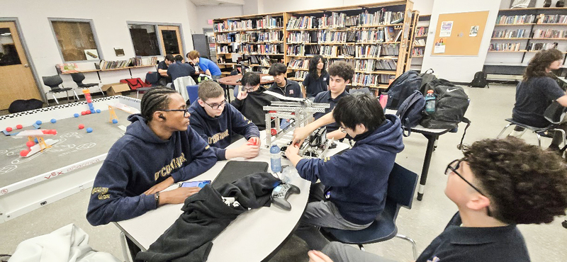 Photo of the OCS Robotics team students working on their robot