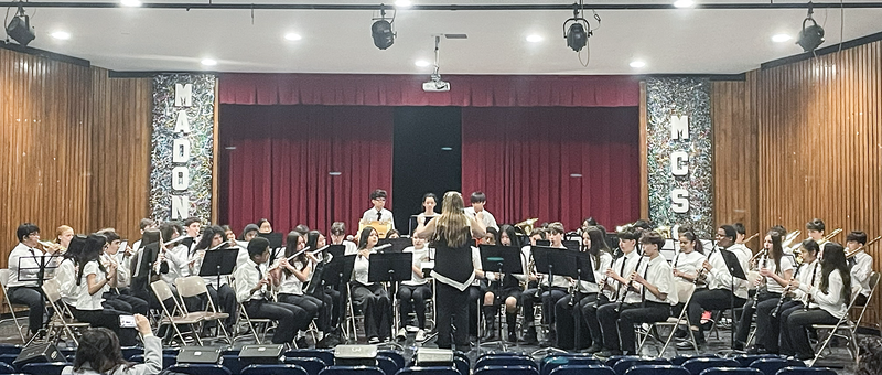 Photo of teacher conducting TCDSB music students on the stage