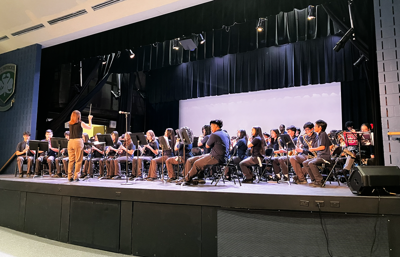 Photo of teacher conducting TCDSB music students on the stage