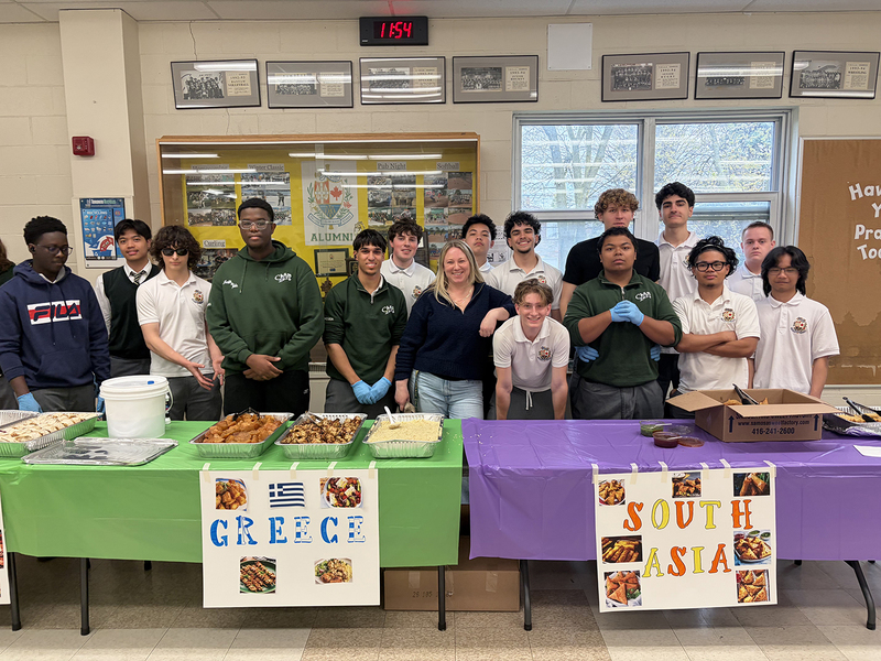 Photo of Chaminade students and staff sanding in front of the Greek and South Asian cultural tables