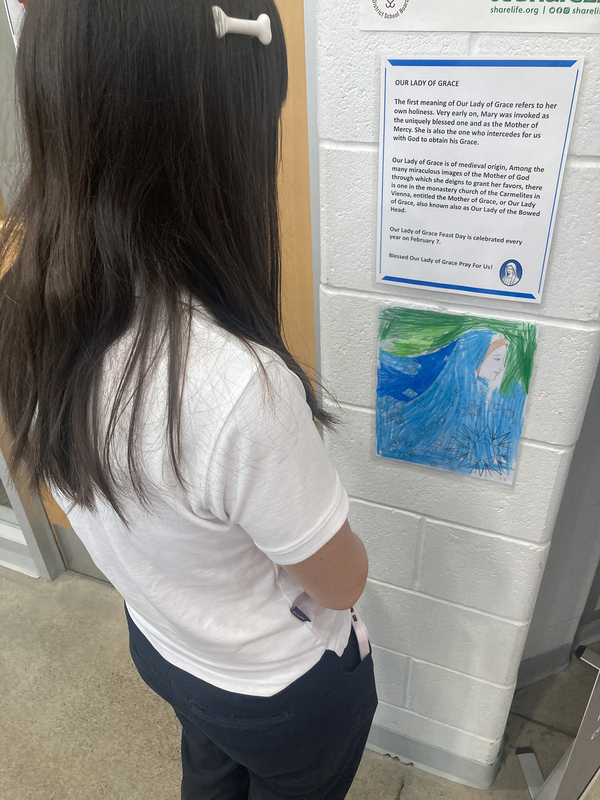 Students reflecting on and praying to Mary at a station during the walk