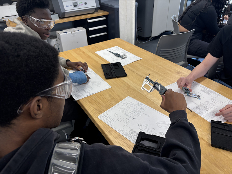 Photo of students working together on Aviation math with special measuring tools during the event