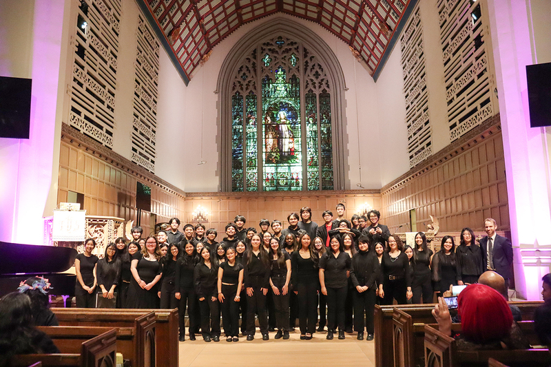 Group photo of the Marshall McLuhan choir in Timothy Eaton Memorial Church with audience members in the pew