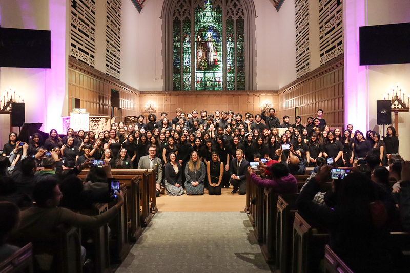 Group photo of the Senator O'Connor, SJMP and Marshall McLuhan choirs together in Timothy Eaton Memorial Church with audience members in the pew