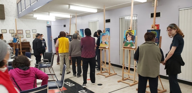 Students showcase art exhibits at Piece Out presentation while members of the school community look at the art Students showcase art exhibits at Piece Out presentation while members of the school community look at the art