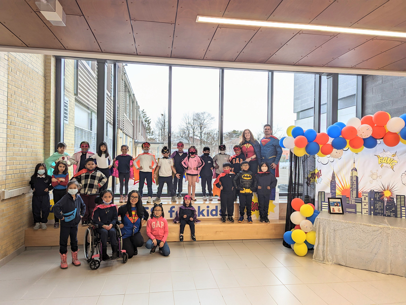 Group photo of St. Paschal Baylon students and staff, most of them in various superhero costumes