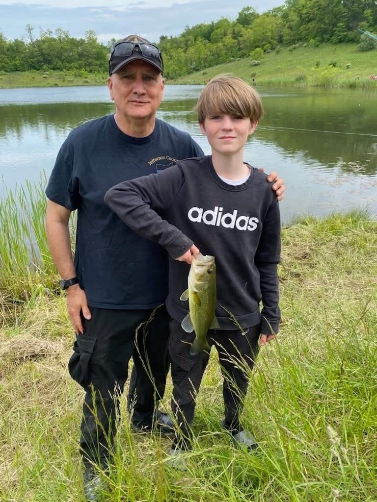 SRO Greg Mamula pictured with a THS student holding a fish.