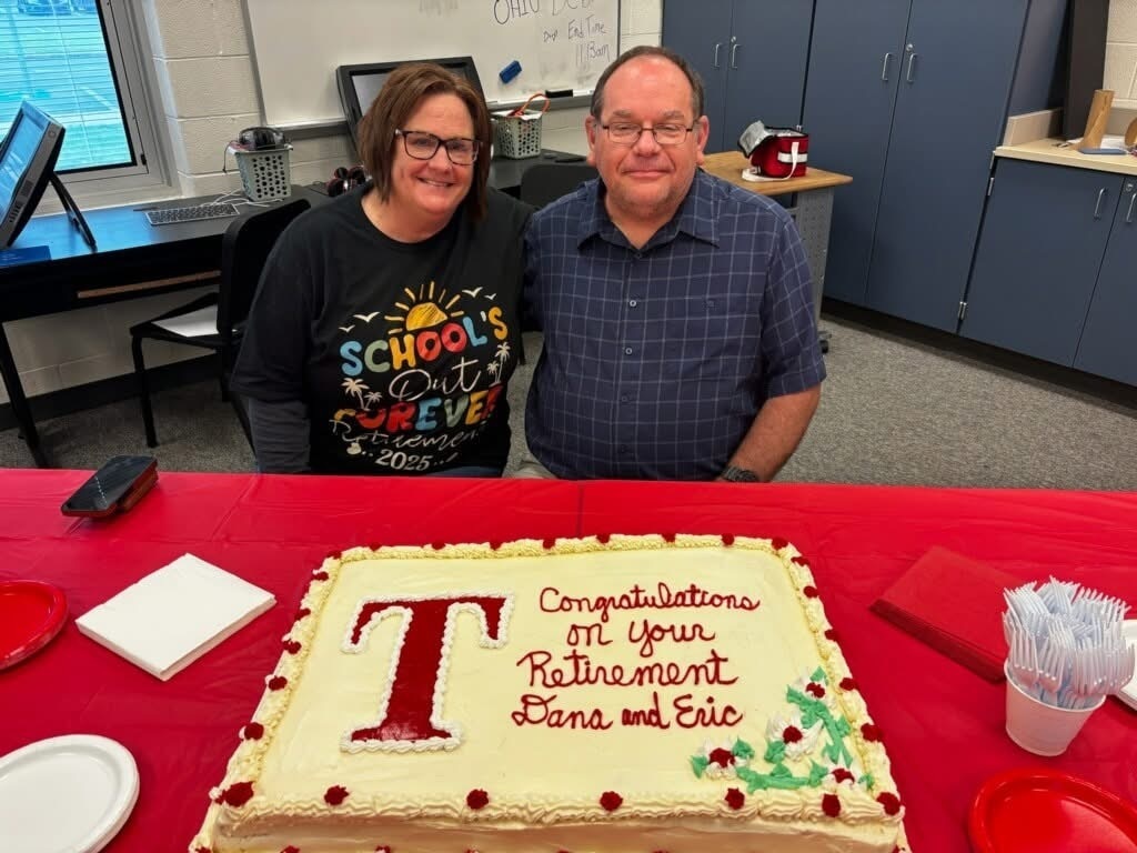 Teachers Dana Kinsey and Eric Meek pictured in front of a cake to celebrate their retirement.